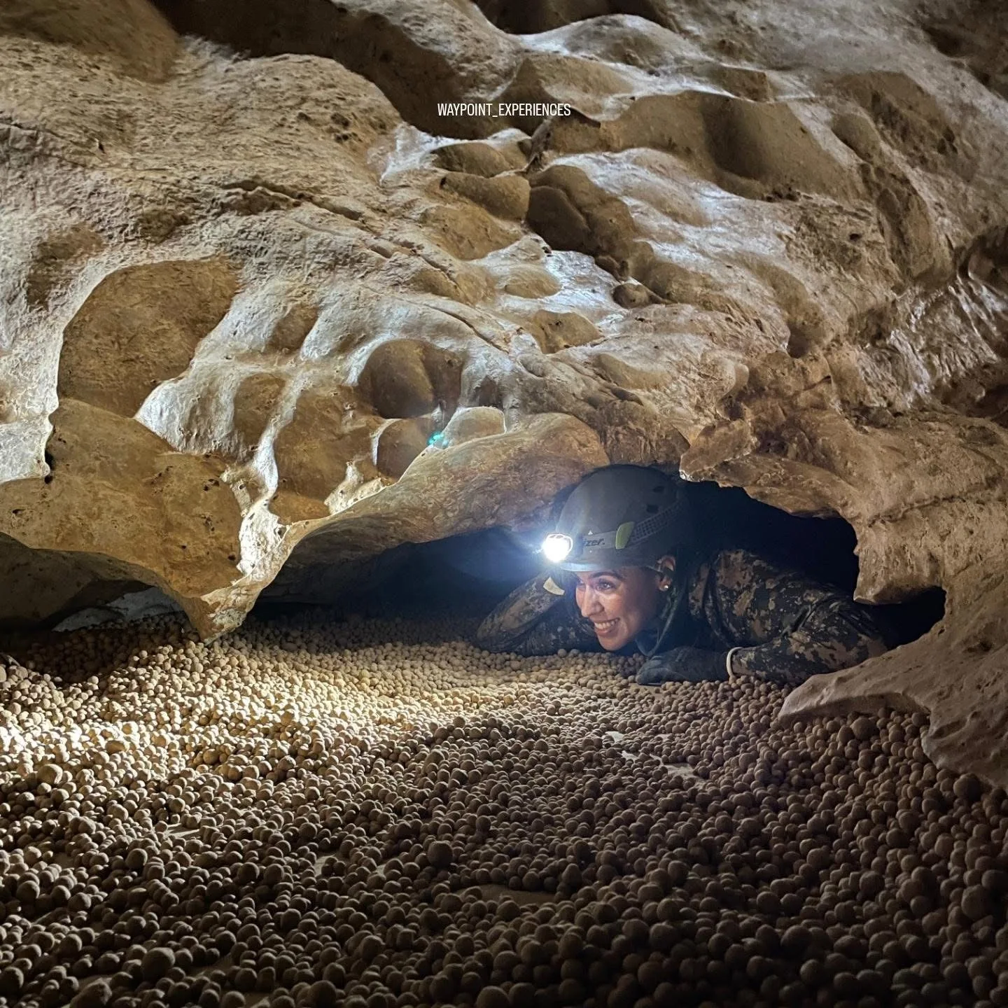 Exploradora avanzando por un paso estrecho en una cueva